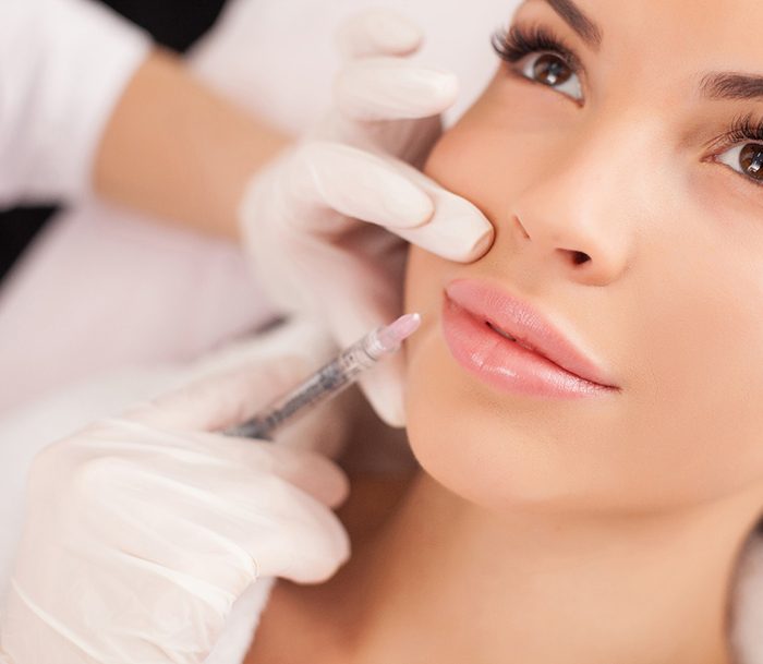 Woman with brown eyes receiving BOTOX injection around lips