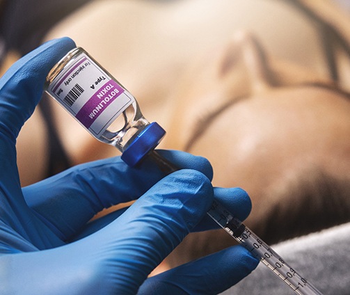 Closeup of gloved hand preparing BOTOX® injection