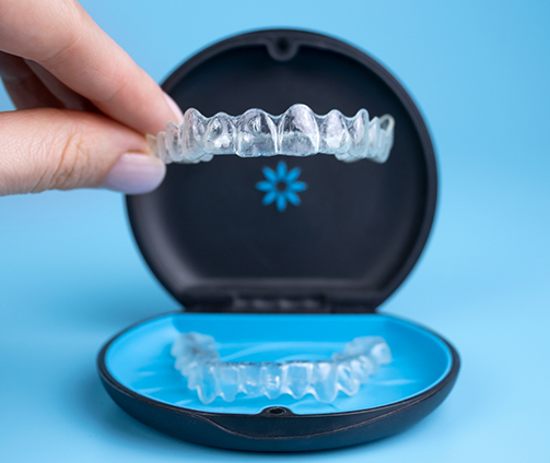 Hand holding an Invisalign clear aligner